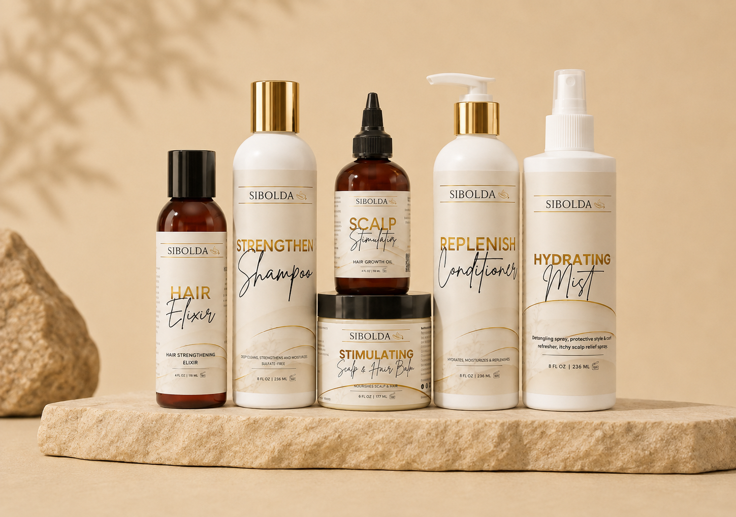 The six-piece Sibolda Starter Ritual Kit — hair elixir, strengthen shampoo, scalp stimulating oil, scalp and hair balm, replenish conditioner and hydrating mist — on a stone plinth